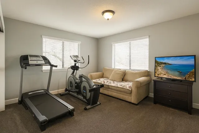 a living room with furniture gym equipment and windows