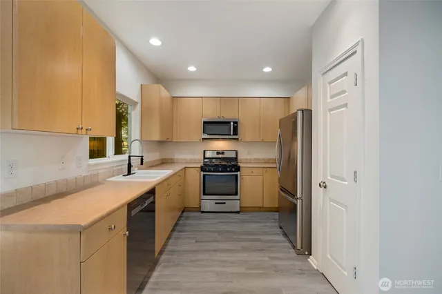 a kitchen with a sink stainless steel appliances and cabinets