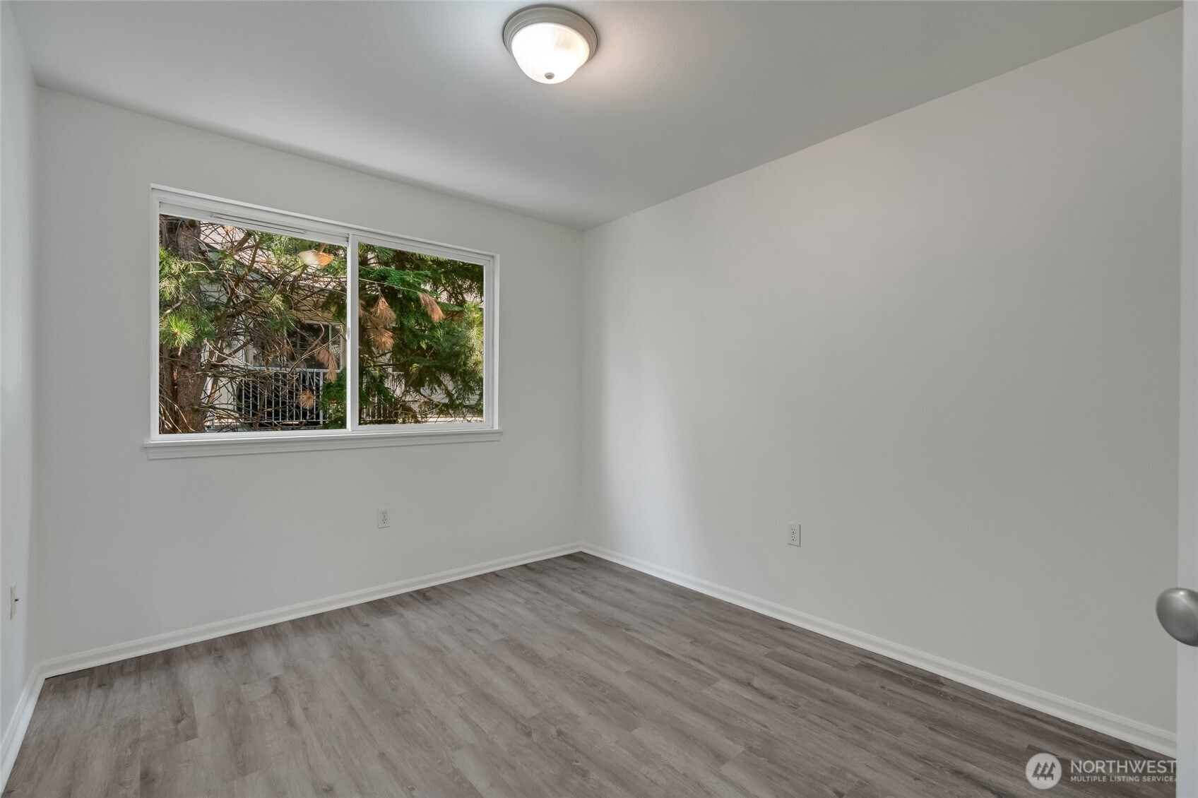 4740 Lake Place South, Unit A Renton, WA 98055 - Photo 19 of 24 an empty room with wooden floor and windows