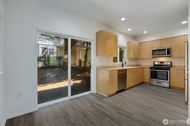 a kitchen with granite countertop a refrigerator and a stove top oven