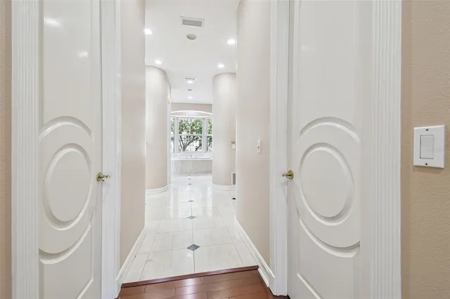an empty room with wooden floor and a ceiling fan
