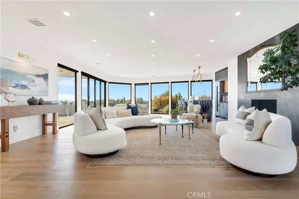 a living room with fireplace furniture and a large window
