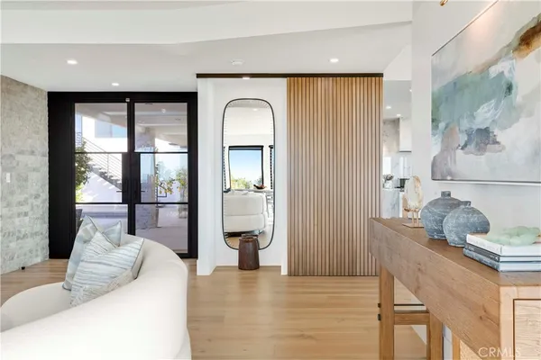 a dining room with furniture a floor to ceiling window and wooden floor