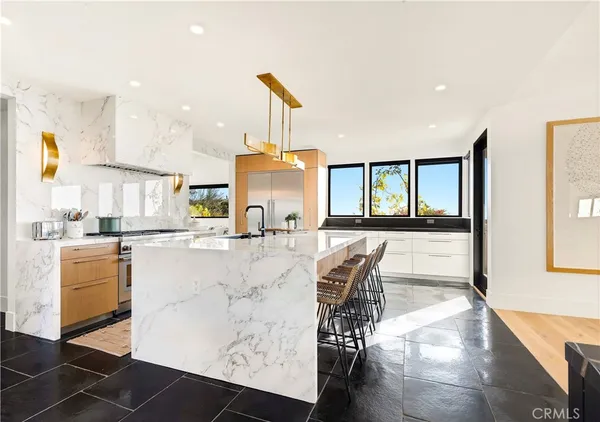 a large kitchen with kitchen island granite countertop a large counter top and stainless steel appliances