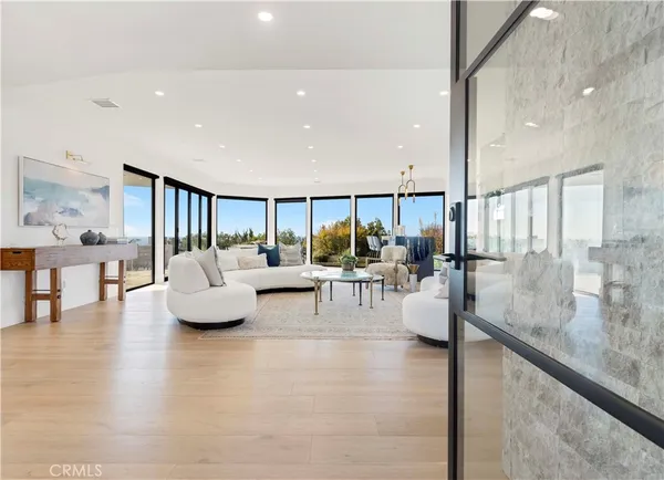 a living room with furniture a large window and stainless steel appliances
