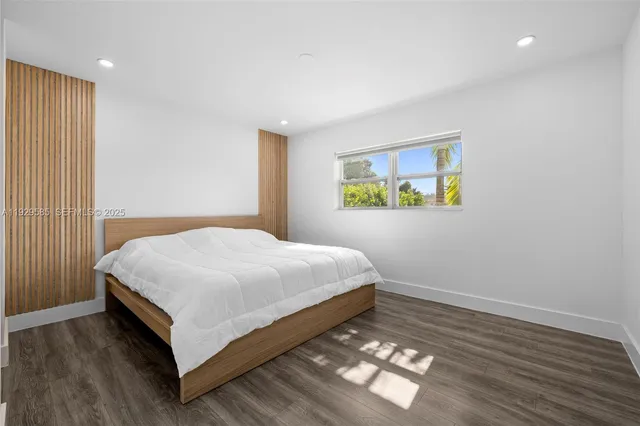 a bedroom with a bed and painting on the wall