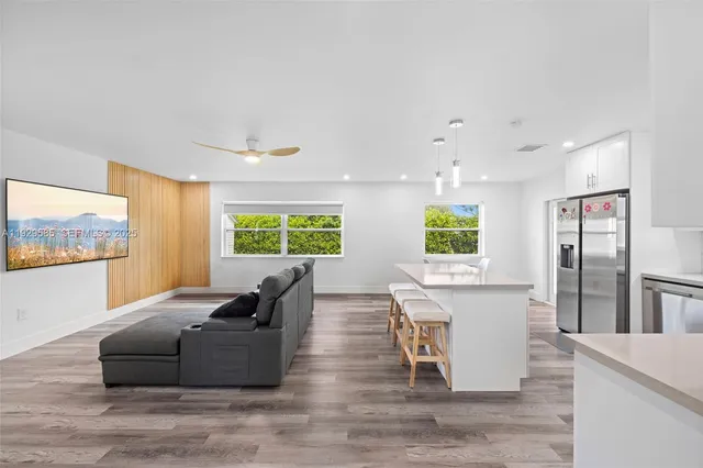 a living room with furniture large window and wooden floor