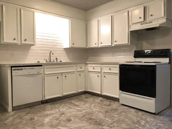 a kitchen with white cabinets stainless steel appliances and sink