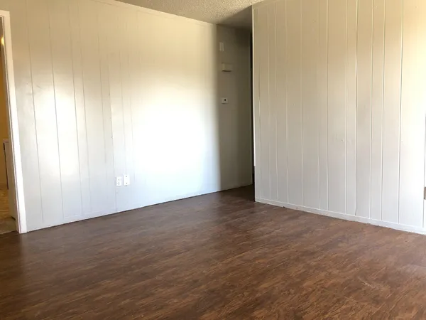a view of an empty room with wooden floor