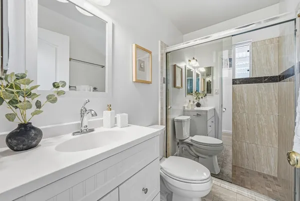 a bathroom with a sink a toilet and shower