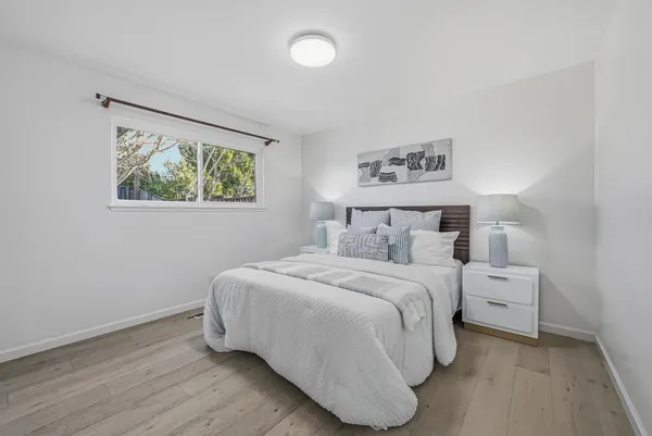 a bedroom with a bed and a painting on the wall
