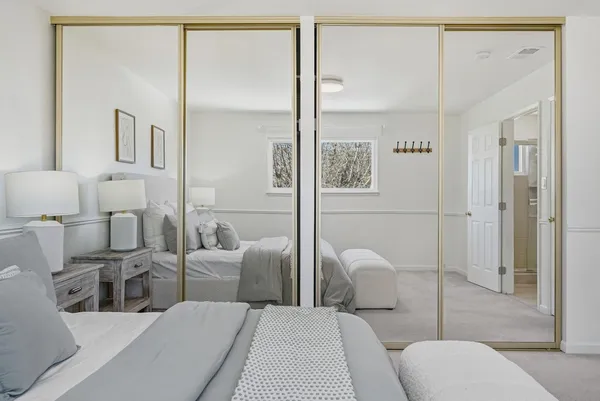 a hotel room with large mirror and furniture