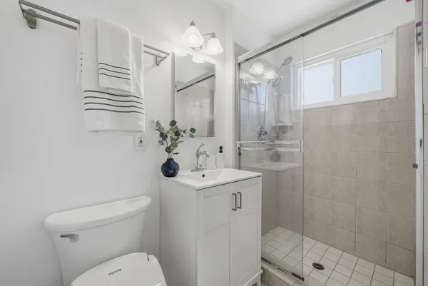 a bathroom with a sink a toilet and shower