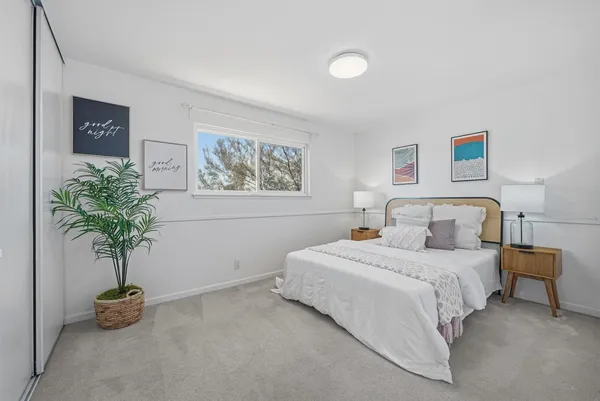a bedroom with bed and a potted plant