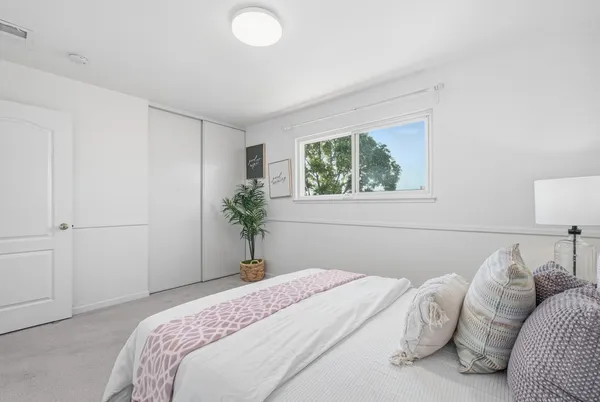 a bedroom with a bed and a potted plant