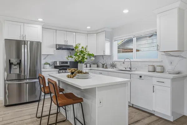 a kitchen with stainless steel appliances a sink stove and refrigerator