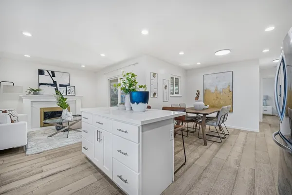 a living room with furniture a dining table and chairs with wooden floor