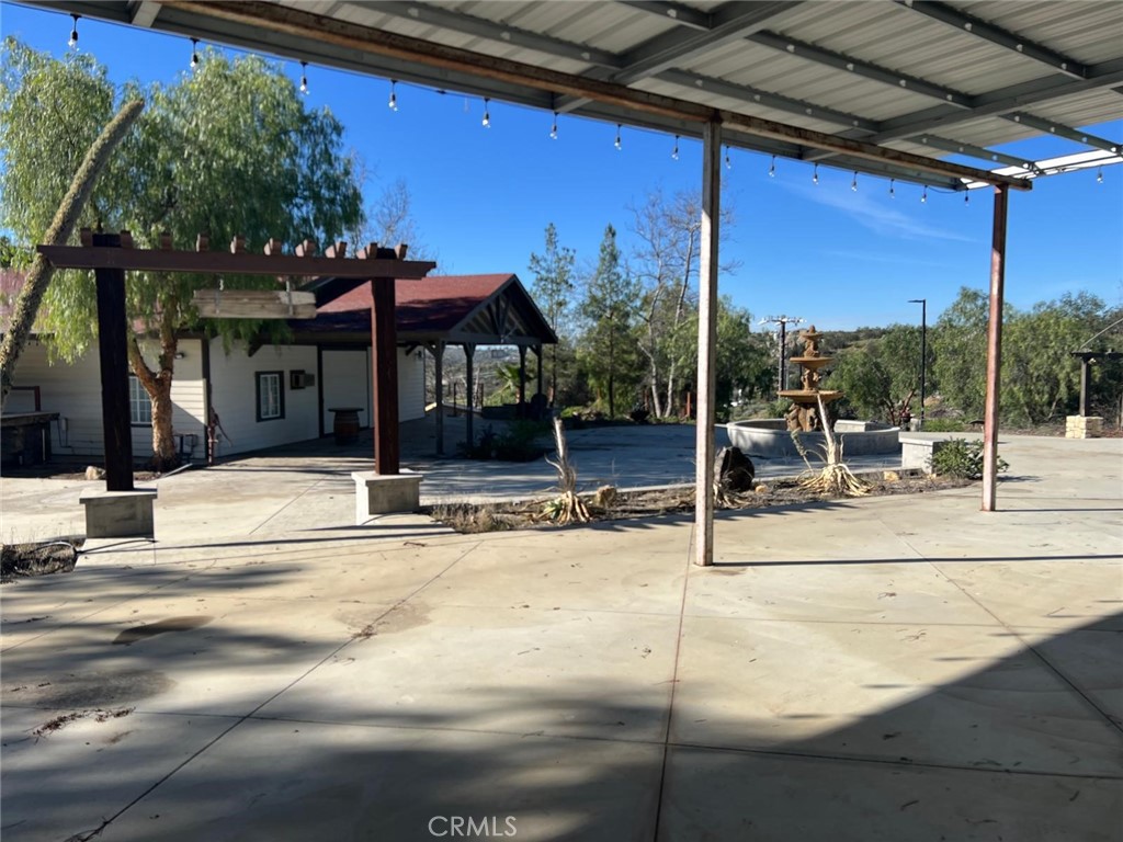 37220 Quarter Valley Road Temecula, CA 92592 - Photo 15 of 24 a view of a patio with a table and chairs under an umbrella