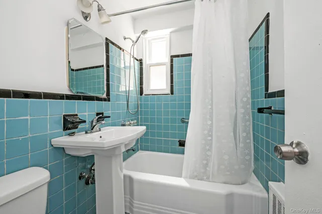 a bathroom with a sink mirror toilet and bathtub