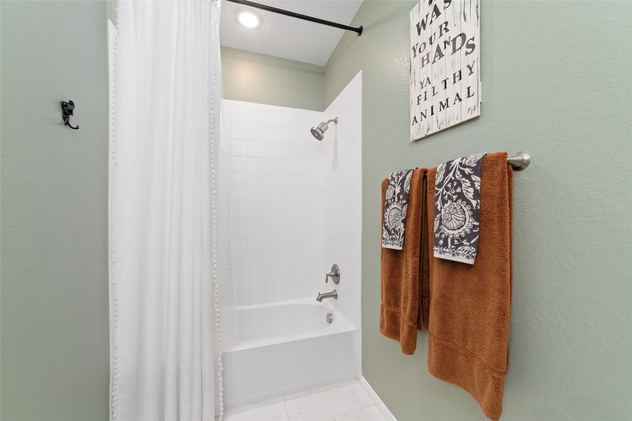 9902 Indian Rill Court Tomball, TX 77375 - Photo 21 of 34 Secondary bathroom with matching white cultured marble countertop, double sinks, and tub/shower combo. Adjacent is a linen closet for extra storage.
