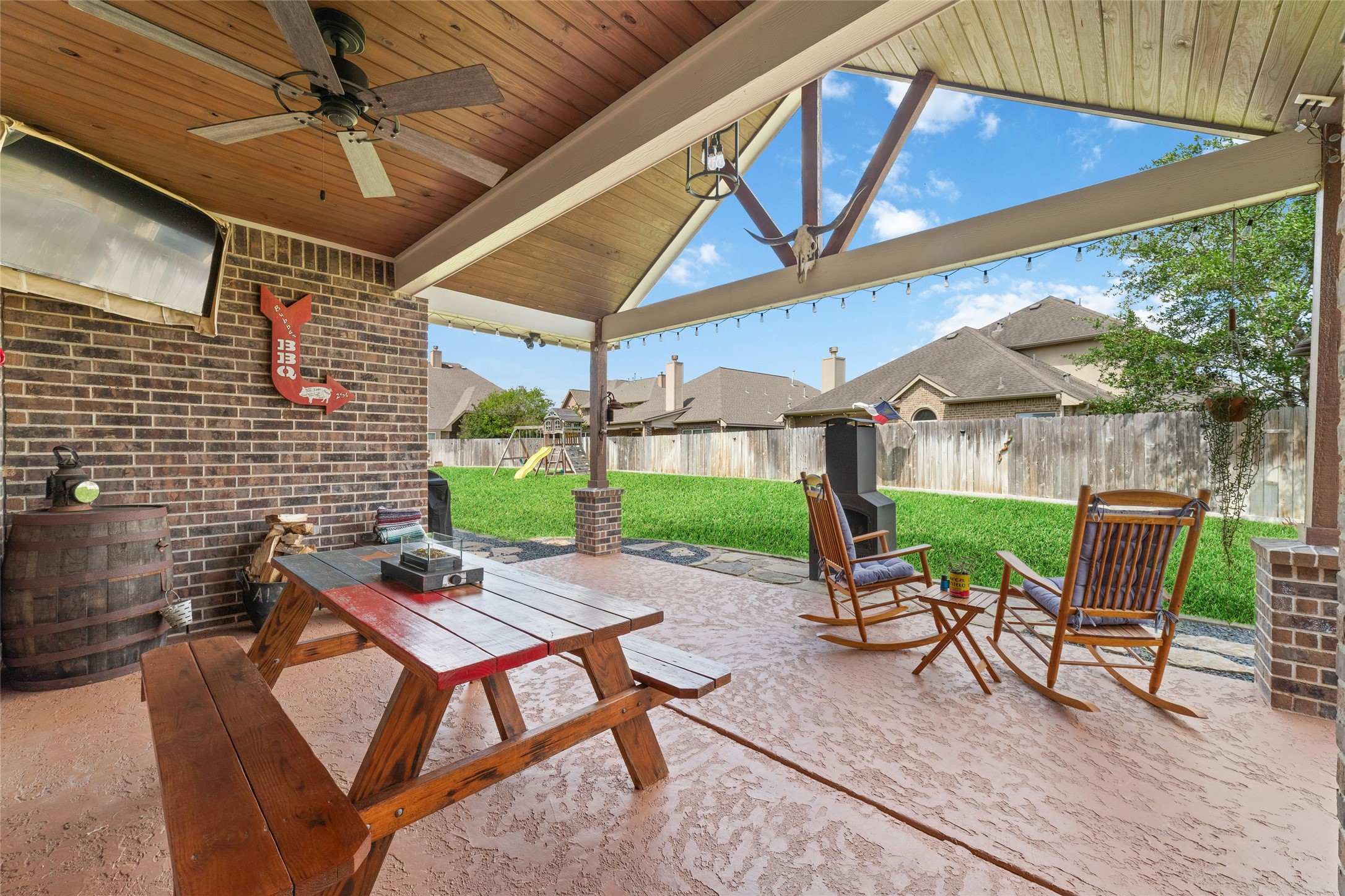 9902 Indian Rill Court Tomball, TX 77375 - Photo 23 of 34 Enjoy the endless summers on your newly custom built extended patio with T&G vaulted ceiling. Keeping it cool with the installed cool deck. Custom landscaping border adds additional usable space and elevates the outdoor living space even more!