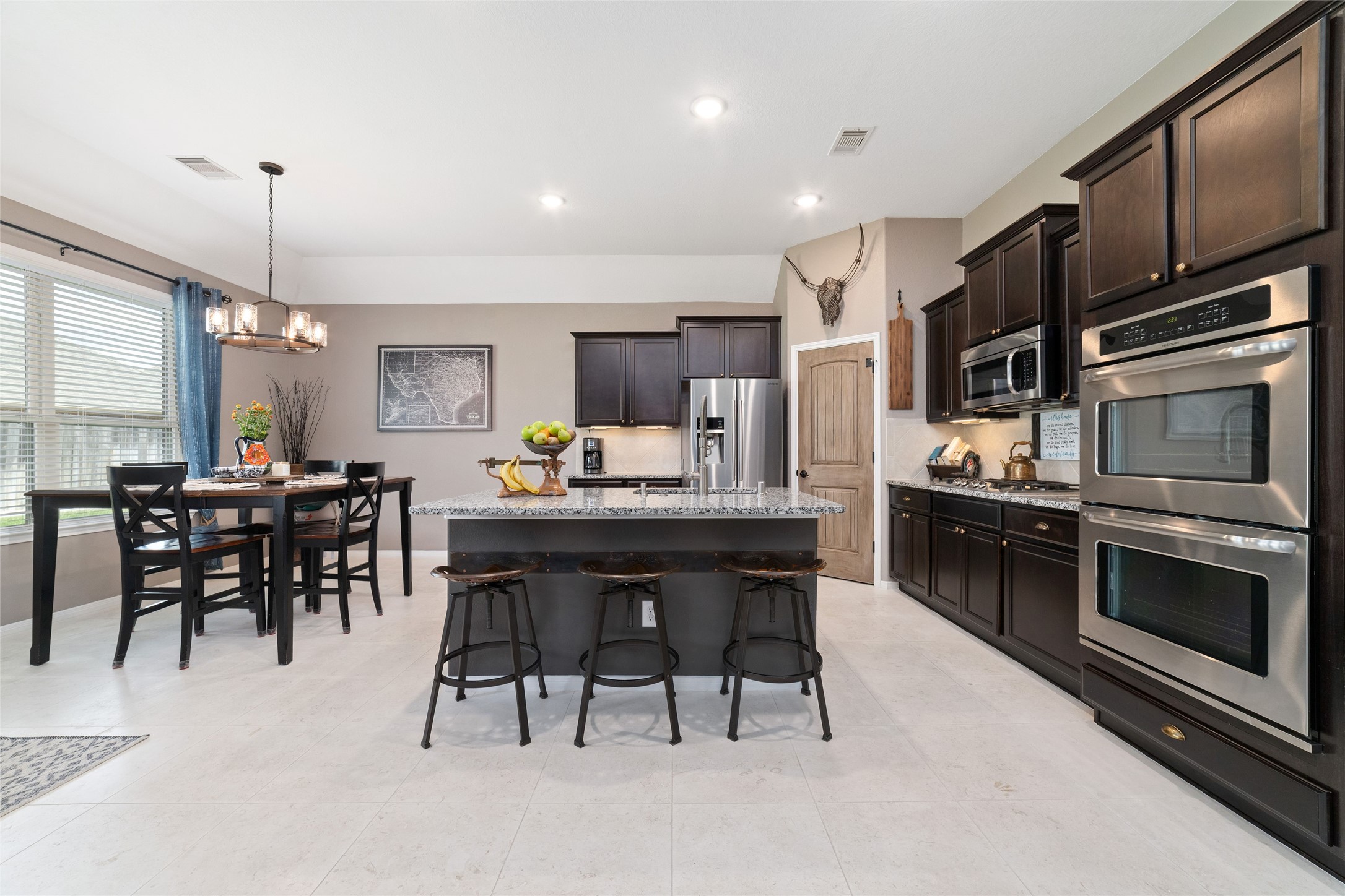 9902 Indian Rill Court Tomball, TX 77375 - Photo 6 of 34 Functional and large kitchen with granite countertops and stainless steel appliances, including a double oven! Gas burner cooktop. Eat-in kitchen island with sink. Large walk-in pantry. Tons of storage & usable counter space!