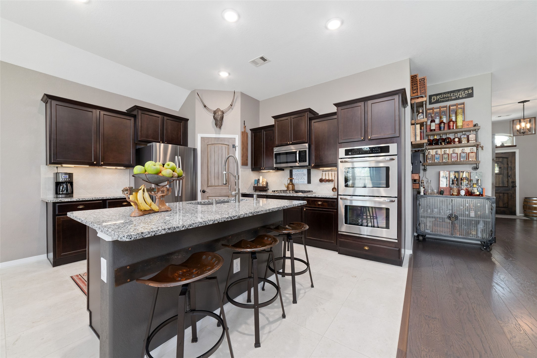 9902 Indian Rill Court Tomball, TX 77375 - Photo 7 of 34 Functional and large kitchen with granite countertops and stainless steel appliances, including a double oven! Gas burner cooktop. Eat-in kitchen island with sink. Large walk-in pantry. Tons of storage & usable counter space!