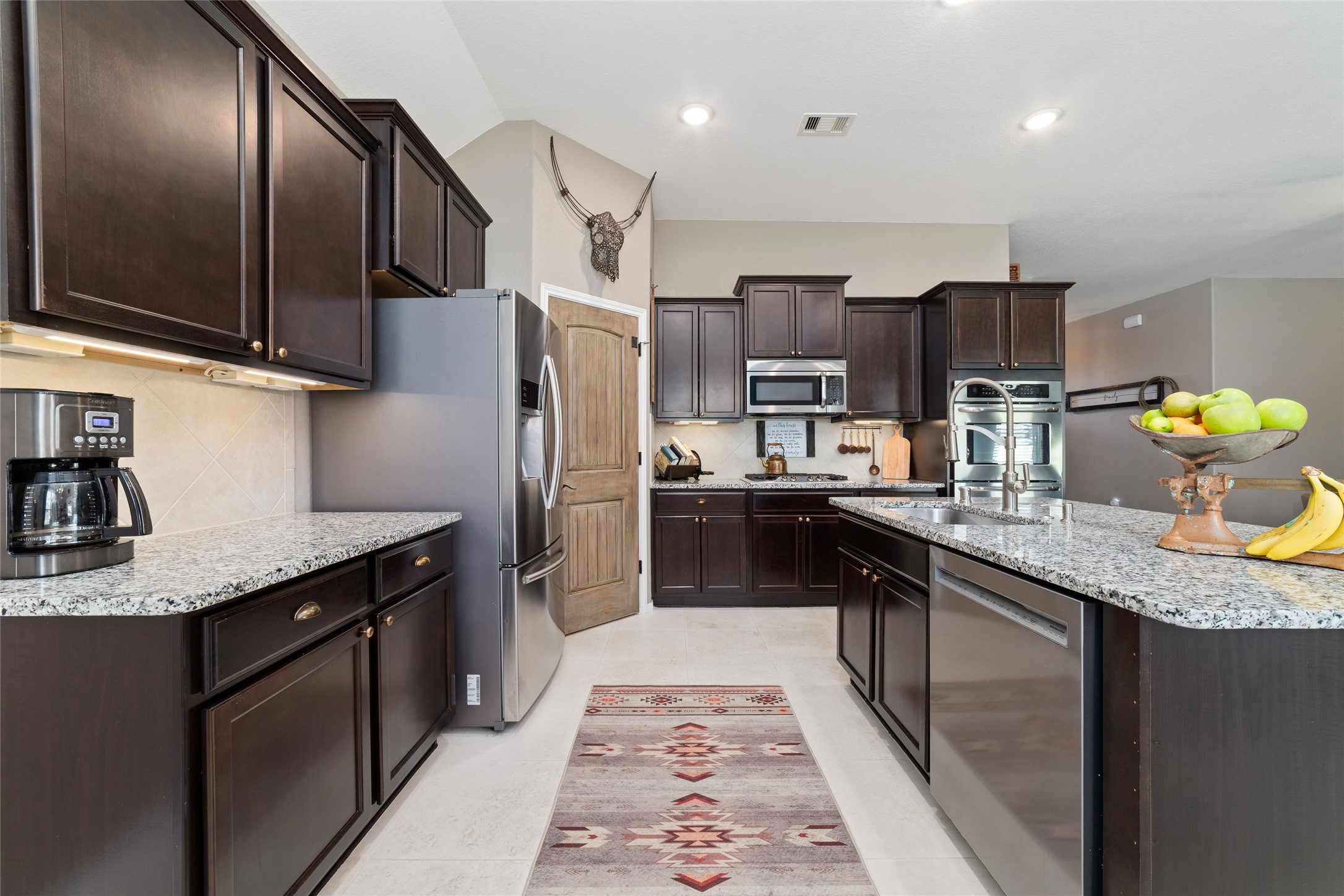 9902 Indian Rill Court Tomball, TX 77375 - Photo 8 of 34 Functional and large kitchen with granite countertops and stainless steel appliances, including a double oven! Gas burner cooktop. Eat-in kitchen island with sink. Large walk-in pantry. Tons of storage & usable counter space!