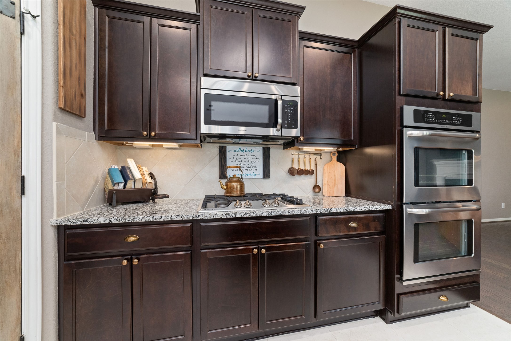 9902 Indian Rill Court Tomball, TX 77375 - Photo 9 of 34 Functional and large kitchen with granite countertops and stainless steel appliances, including a double oven! Gas burner cooktop. Eat-in kitchen island with sink. Large walk-in pantry. Tons of storage & usable counter space!