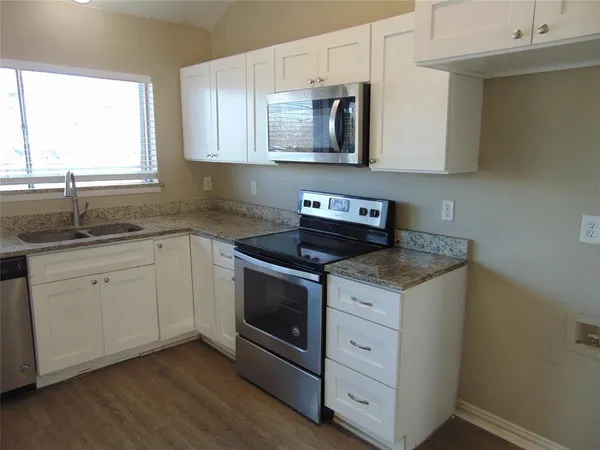 a kitchen with stainless steel appliances granite countertop a sink and a stove