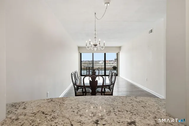 a view of a dining room with furniture and floor to ceiling window