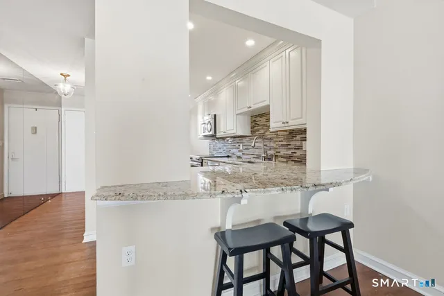 a kitchen with stainless steel appliances granite countertop a sink and a refrigerator