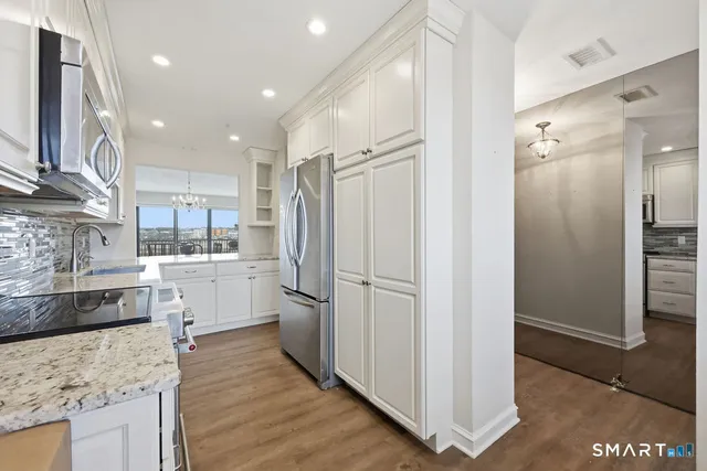 a kitchen with white cabinets and stainless steel appliances