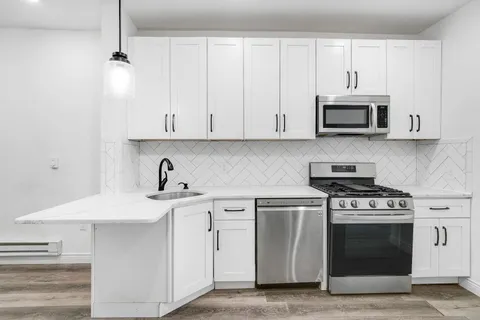 a kitchen with stainless steel appliances granite countertop a sink and a stove