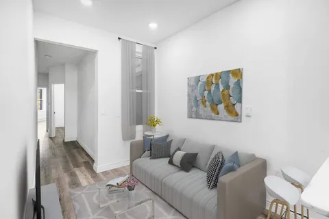 a living room with furniture and a painting on the wall