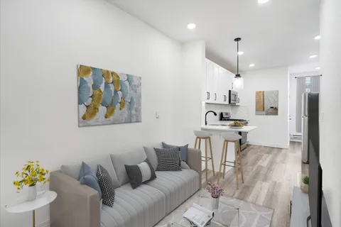 a living room with stainless steel appliances kitchen island granite countertop furniture and a view of kitchen