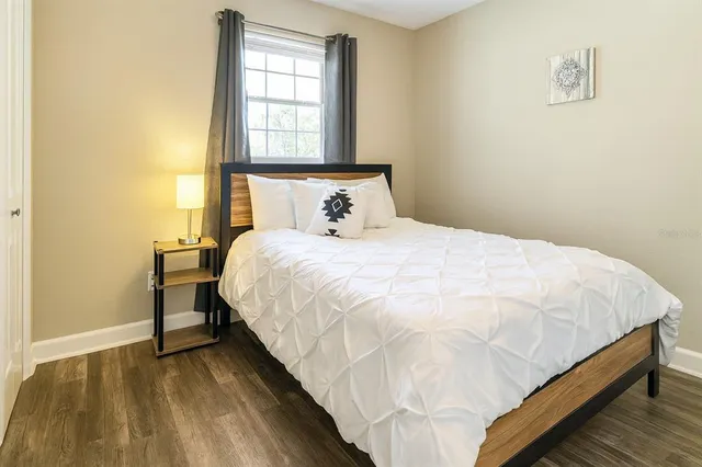 a bedroom with a bed and wooden floor