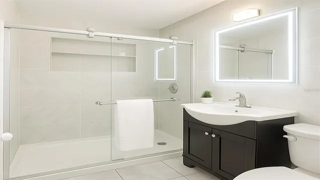 a bathroom with a granite countertop sink toilet and shower