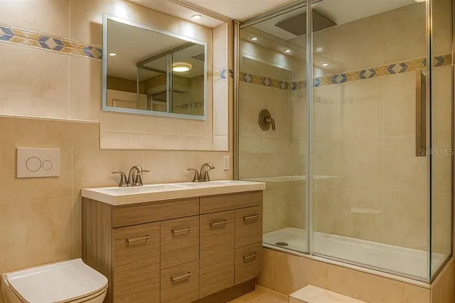 a spacious bathroom with a granite countertop sink toilet mirror and bathtub