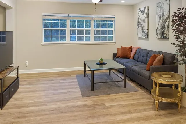 a living room with furniture and a floor to ceiling window
