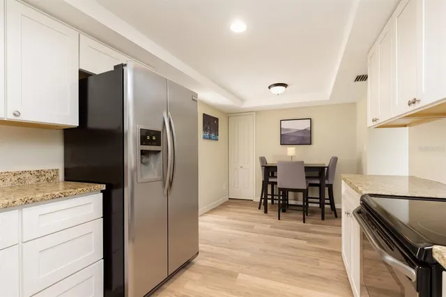 a kitchen with stainless steel appliances granite countertop a refrigerator stove microwave and cabinets