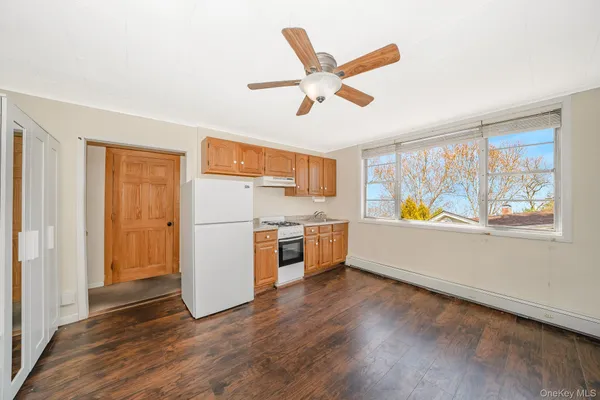 a view of a kitchen with wooden floor and electronic appliances