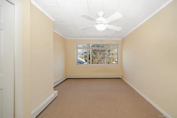 an empty room with windows and fan