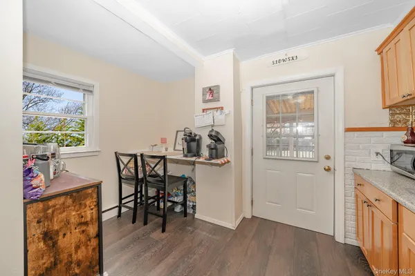 a view of a workspace with furniture and a window