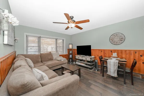 a living room with furniture kitchen view and a window
