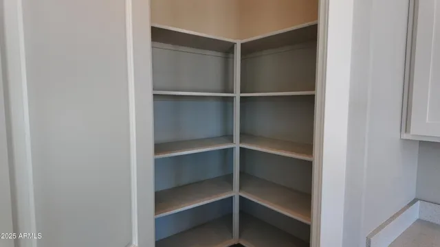 a view of walk in closet with empty racks