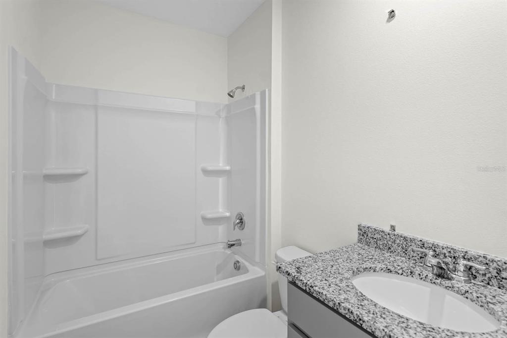 1217 Alstonia Mount Mount Dora, FL 32757 - Photo 29 of 33 a bathroom with a granite countertop sink toilet and bathtub