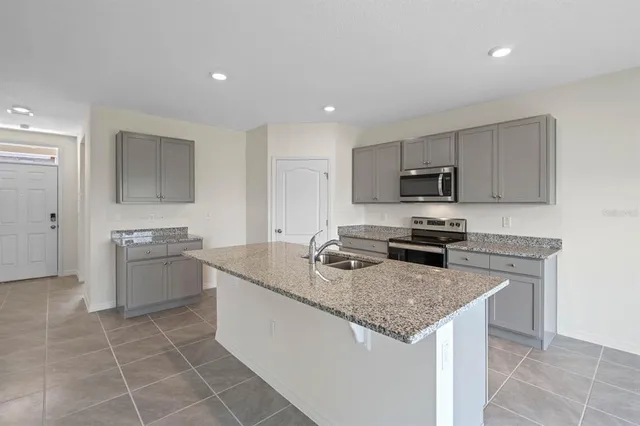 a kitchen with stainless steel appliances granite countertop a sink dishwasher stove top oven and refrigerator
