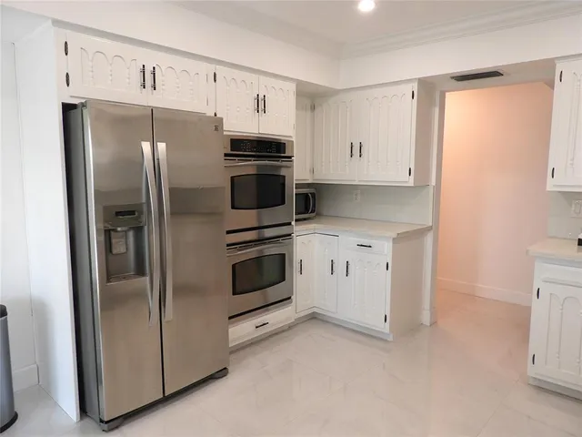 a kitchen with stainless steel appliances granite countertop a refrigerator sink and cabinets