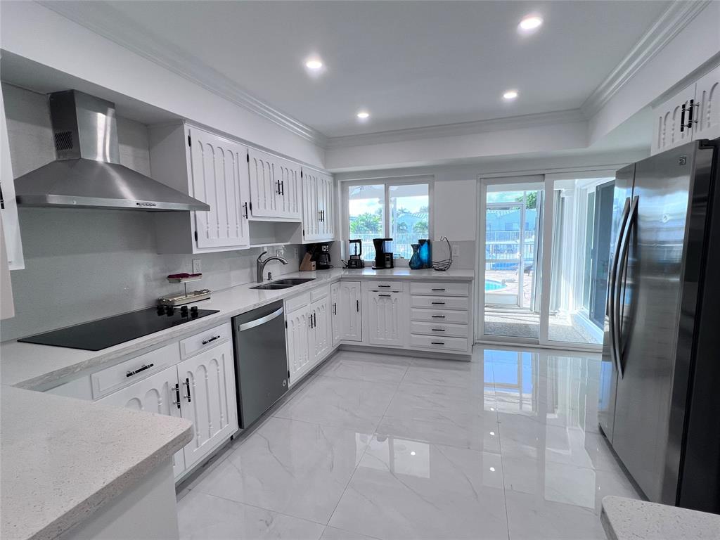 4101 Northeast 24th Avenue Lighthouse Point, FL 33064 - Photo 14 of 30 a kitchen with stainless steel appliances granite countertop a refrigerator sink and cabinets